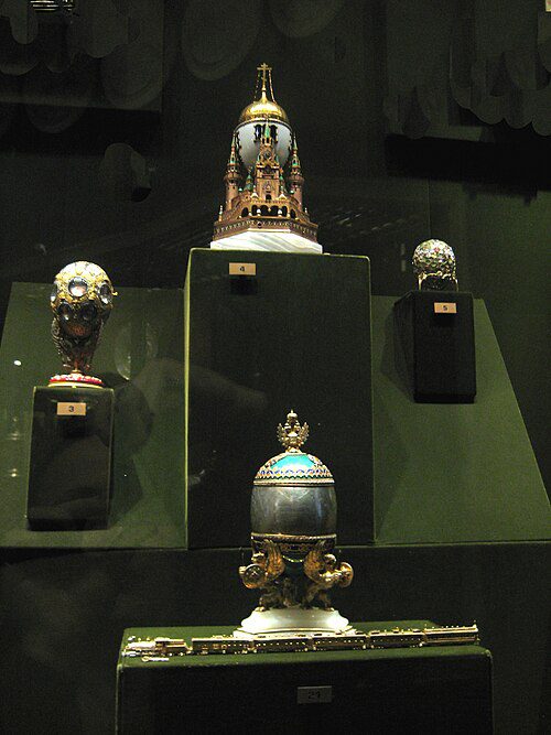A collection of Fabergé eggs and imperial Russian artifacts displayed in a museum case
