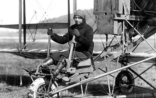 Pioneering American aviator Ruth Law standing beside her biplane in flight uniform, circa 1916