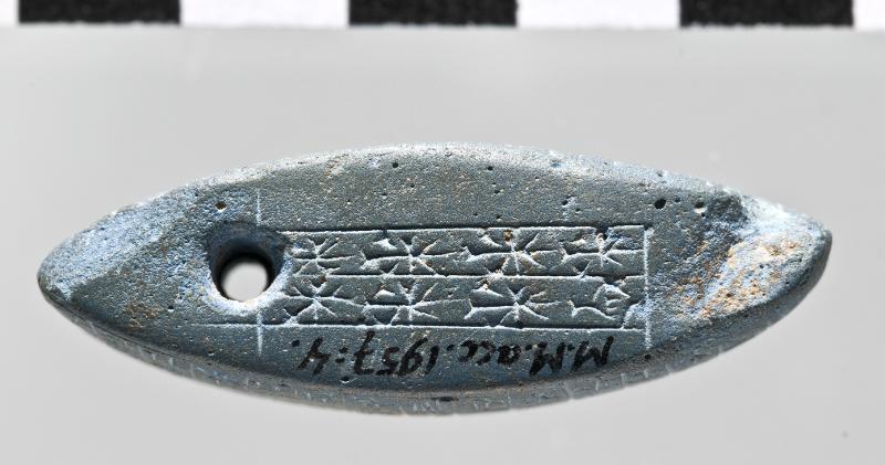 A Sumerian foundation tablet carved from lapis lazuli, bearing a cuneiform inscription.