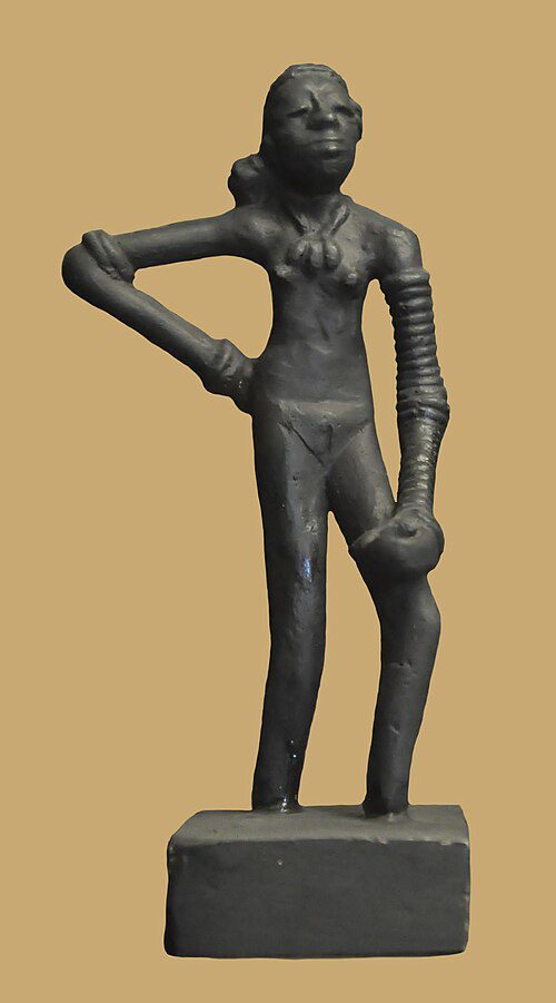 Small bronze statuette of a standing girl wearing bangles, one hand on her hip