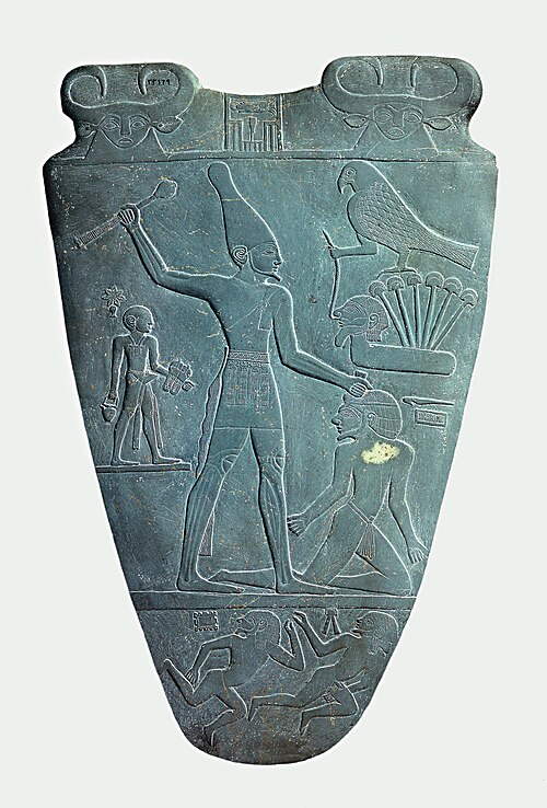 Dark siltstone ceremonial palette carved with relief scenes of an Egyptian king