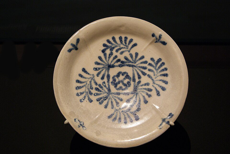A white Tang Dynasty dish decorated with cobalt-blue overlapping lozenge and foliate motifs