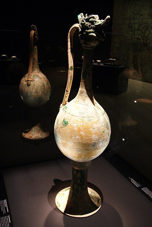 A tall Tang Dynasty ceramic ewer with a dragon-head stopper and green-splashed glaze