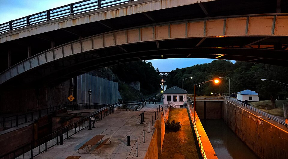 A wide stone staircase of locks alongside a modern electric canal lock.