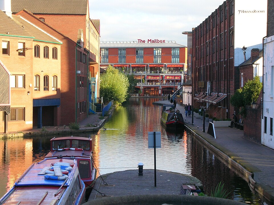 A dense urban canal basin filled with long, narrow painted boats.