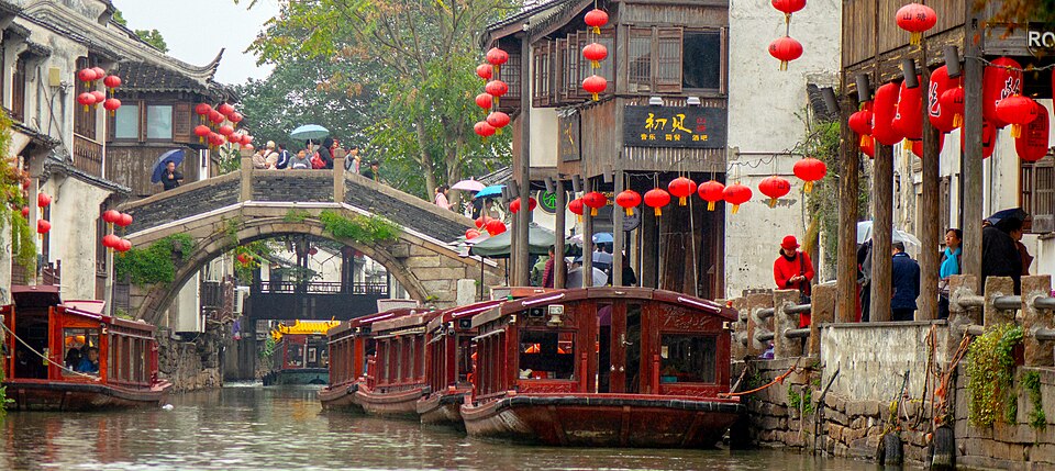 Traditional whitewashed houses built directly over granite-lined urban canal branches.